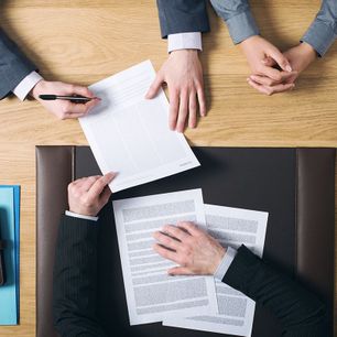 Top view of lawyer and clients signing documents